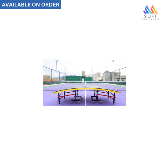 Indoor Teqball table with a purple playing surface, black frame and wheels, placed on a sports court.